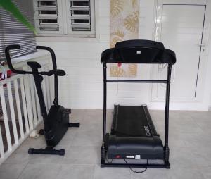 a treadmill and an exercise bike in a room at Villa Madras in Sainte-Anne