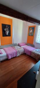 two beds in a room with wood floors at La casa degli Elfi a Monfalcone in Monfalcone