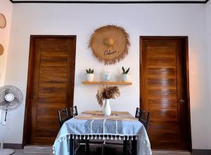 a dining room with a table and two doors at Liminaya Villa in El Nido +1 photo