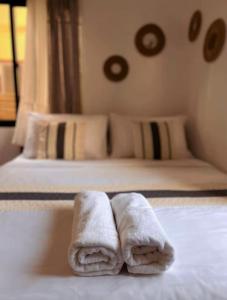 two towels on a bed in a hotel room at Liminaya Villa in El Nido