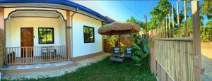 a small house with an umbrella and a fence at Liminaya Villa in El Nido