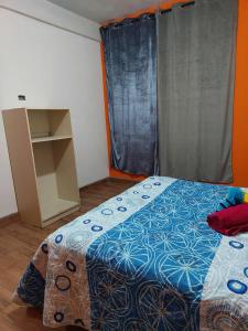 a bedroom with a bed with a blue comforter at Armonías 2 in Panajachel
