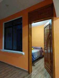a room with a bedroom with a bed and a window at Armonías 2 in Panajachel