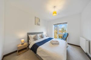 a bedroom with a large bed and a window at Stylish long & short stay flat with parking & Wifi sleeps 5 in Maidstone