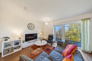 a living room with a couch and a tv at Stylish long & short stay flat with parking & Wifi sleeps 5 in Maidstone
