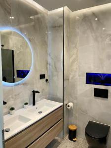 a bathroom with a sink and a toilet and a mirror at Aura Spa Oberhausen Premium in Oberhausen +5 photos