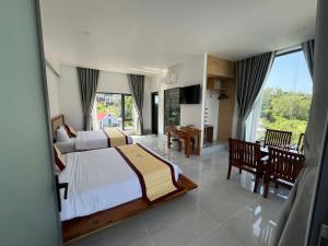 a bedroom with a bed and a table and chairs at Villa caribe phu quoc in Phú Quốc