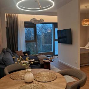a living room with a table and a couch at Park View Olszynki Park in Rzeszów