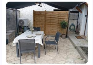 a white table and chairs in a patio at L oxygène ardéchois gîte 3 in Ruoms