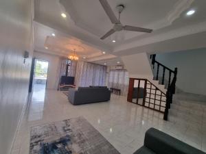 a living room with a couch and a ceiling fan at D' Saras Homestay in Sitiawan +2 photos