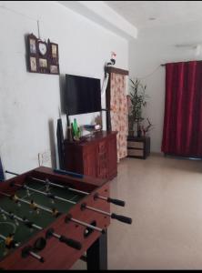 a living room with a pool table and a tv at COORG CLlMATE FARM HOUSE in Madikeri