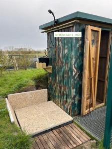 a out house with a bench in front of it at Nature en Somme in Quend