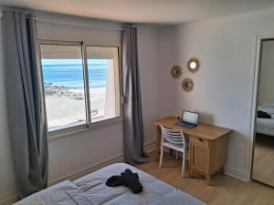 a bedroom with a desk with a laptop and a window at Horizon Bleu Duplex 2 chambres vue mer in Palavas-les-Flots