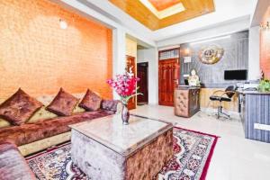 a living room with a couch and a table at Nirvana Rooms - Shimla in Shimla
