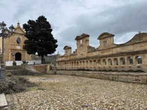 an old building with a tree in the middle of a courtyard at Dejavu ROOMS & SPA in Assoro