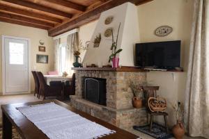 a living room with a stone fireplace and a television at Villa Dorothy 360 -Mountain Escape in Polydrosos in Polydrossos