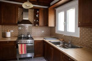 a kitchen with a sink and a stove and a window at Villa Dorothy 360 -Mountain Escape in Polydrosos in Polydrossos