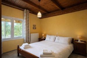 a bedroom with a large white bed with a window at Villa Dorothy 360 -Mountain Escape in Polydrosos in Polydrossos