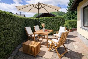 a table and chairs with an umbrella on a patio at House Lenart in Bled