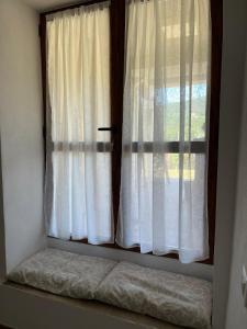 a window with white curtains in a room at Costa Del Sole 48 in Camporsevoli
