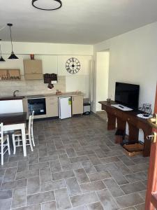 a kitchen with a counter and a table and a clock at Costa Del Sole 48 in Camporsevoli