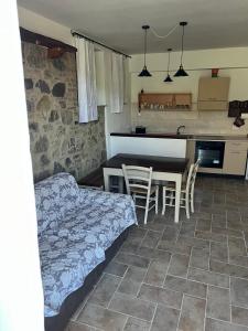 a bedroom with a bed and a table and a kitchen at Costa Del Sole 48 in Camporsevoli