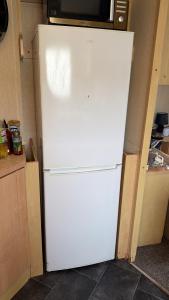 a white refrigerator with a microwave on top of it at sea view caravan park in Ingoldmells