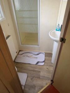a bathroom with a bathmat on the floor next to a sink at sea view caravan park in Ingoldmells