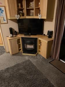 a living room with a television and a fireplace at sea view caravan park in Ingoldmells