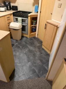 a kitchen with a tile floor and a stove at sea view caravan park in Ingoldmells +7 photos