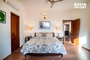 a bedroom with a large bed and a hallway at StayVista at Cedar Crest Villa with Bonfire, Valley View in Kasauli