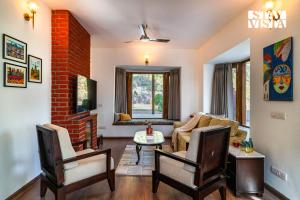 a living room with a couch and a brick wall at StayVista at Cedar Crest Villa with Bonfire, Valley View in Kasauli
