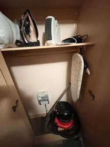 a shelf with a hair dryer and other items on it at Seawick Beach Caravan in Saint Osyth