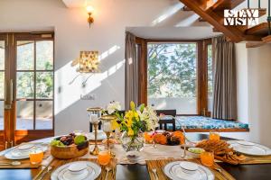 a dining room with a table with food on it at StayVista at Cedar Crest Villa with Bonfire, Valley View in Kasauli