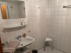 a white bathroom with a sink and a mirror at Ferienwohnung Waldliebe in Waldkirchen