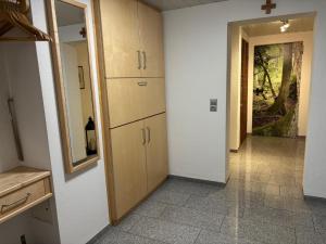 a kitchen with a mirror and cabinets and a hallway at Ferienwohnung Waldliebe in Waldkirchen +7 photos