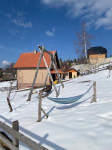 a hammock in the snow in front of a house at BiSER PANČIĆA in Sekulić 