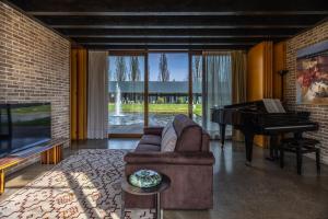 a living room with a couch and a piano at Agriturismo Corte d'acqua in Abano Terme