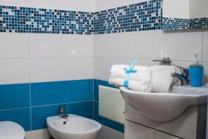 a blue and white bathroom with a sink and a toilet at B & B Victoria in Pompei