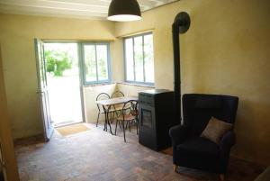 a living room with a chair and a table at Jardin Solstice in Vaupillon +7 photos