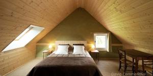 a bedroom with a large bed in a attic at Jardin Solstice in Vaupillon