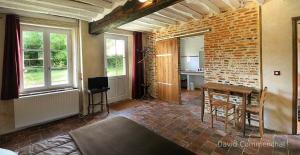 a room with a table and a brick wall at Jardin Solstice in Vaupillon