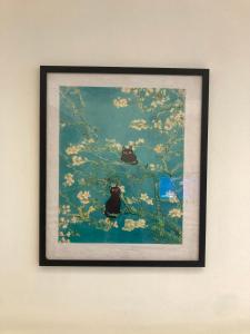 a framed picture of two cats sitting on a tree branch at UrbaNest WCY in Wakaf Che Yeh