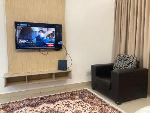 a living room with a flat screen tv on the wall at UrbaNest WCY in Wakaf Che Yeh