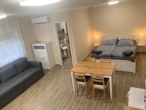 a room with a bed and a table and a couch at Dunaparti Kuckó in Kiskunlacháza