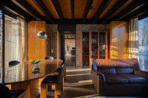 a living room with a table and a leather couch at Agriturismo Corte d'acqua in Abano Terme +17 photos