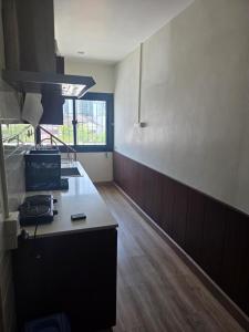 a kitchen with a counter top and a window at Thaiger House Studios in Bangkok