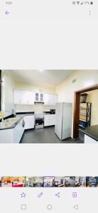 an empty kitchen with white cabinets and appliances at Kigali great homes in Kigali
