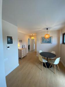 a dining room and living room with a table and chairs at The Costa Suite byArtistunknown in Vari