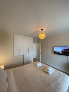 a bedroom with a large bed and a tv on the wall at The Costa Suite byArtistunknown in Vari